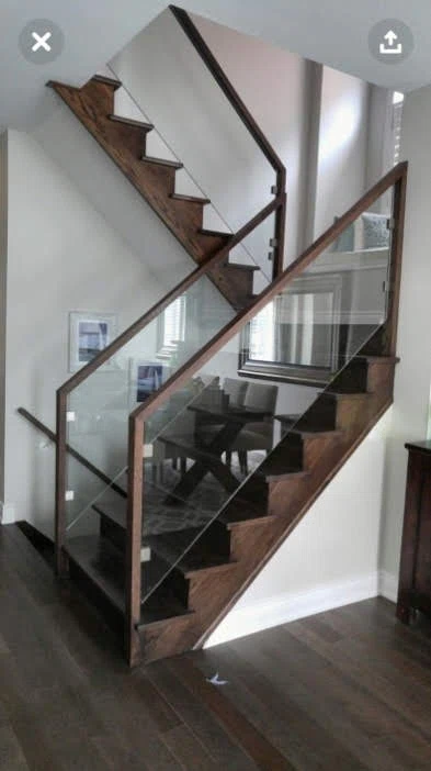 Escalier tournant en bois foncé avec garde-corps de verre