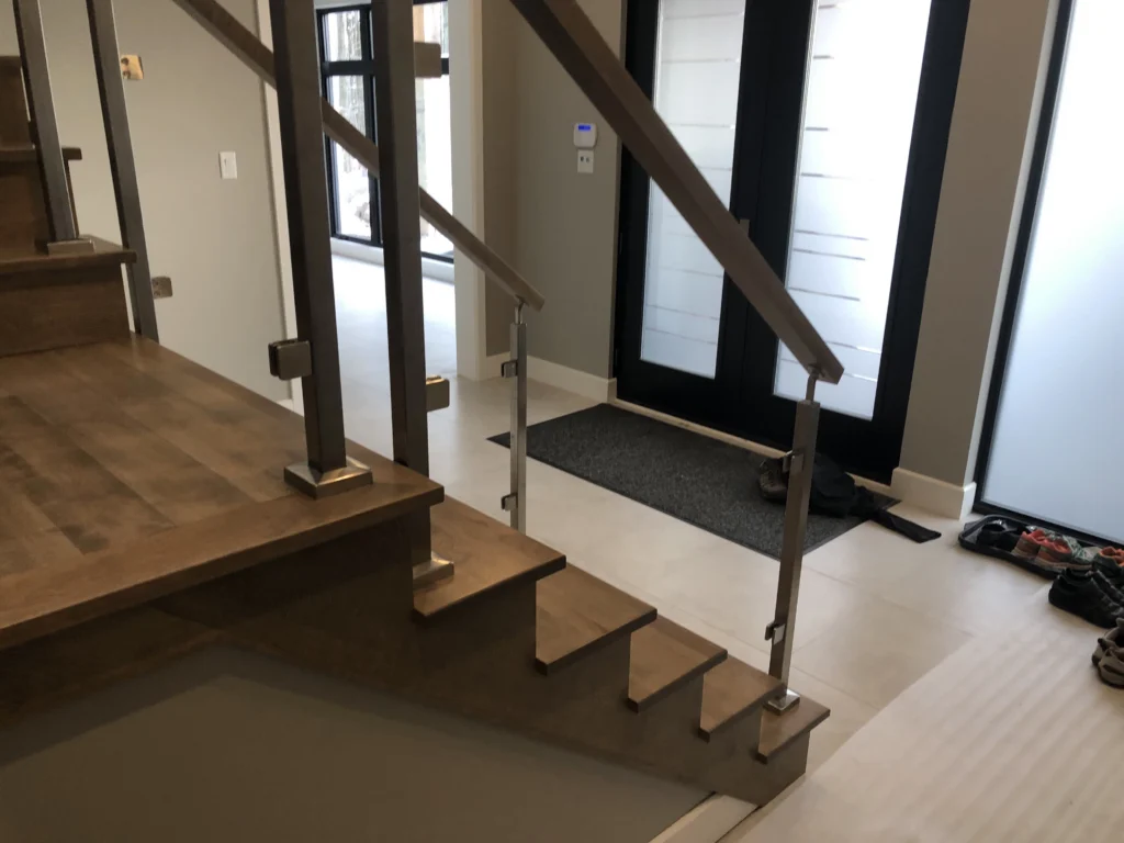 Escalier droit en érable teinté à départ suspendu et garde-corps de verre