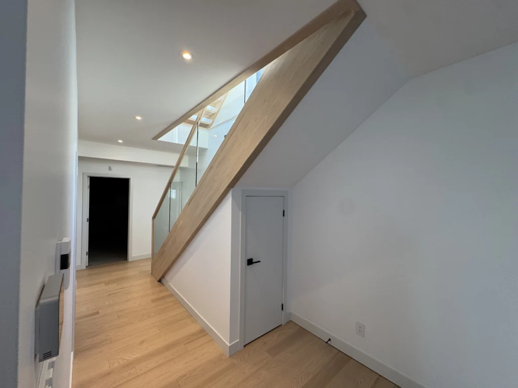 Escalier droit en chêne clair à garde-corps de verre encadré de bois
