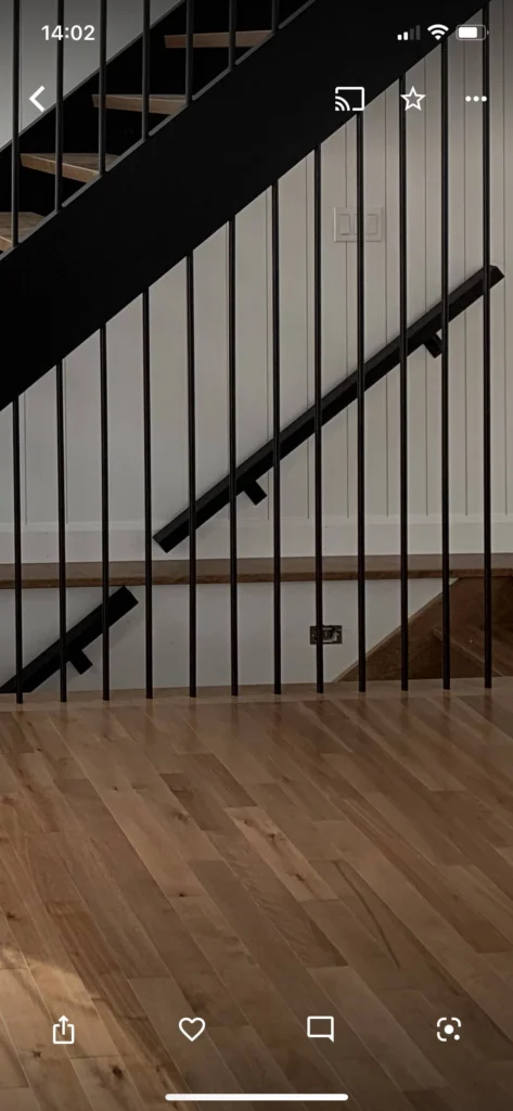 Escalier en bois clair à barreaux métalliques noirs et marches ouvertes
