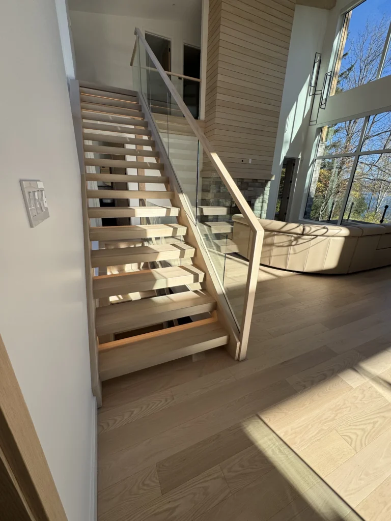 Escalier suspendu en chêne blanc à marches ouvertes et garde-corps de verre