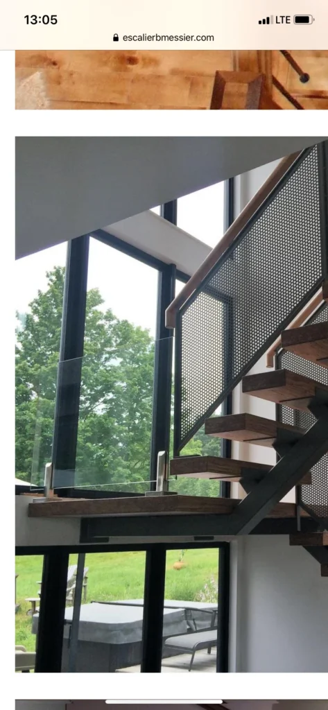 Escalier suspendu en noyer sur limon central d&rsquo;acier à panneau métallique perforé