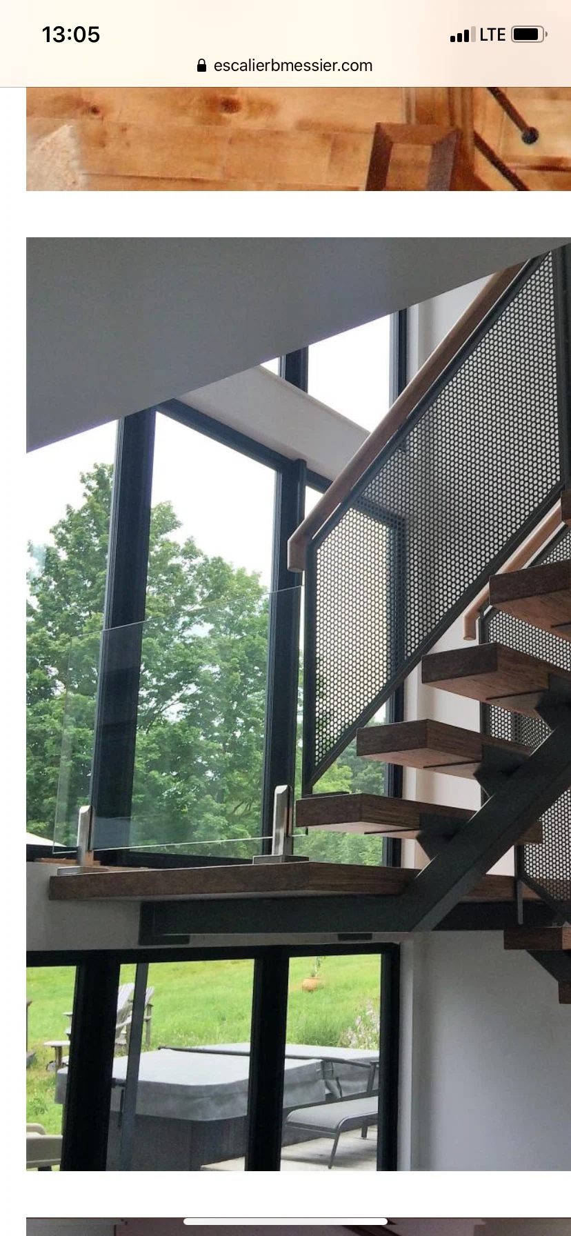 Escalier suspendu en noyer sur limon central d&rsquo;acier à panneau métallique perforé — vue principale