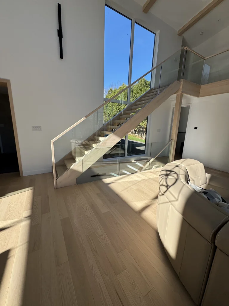 Escalier droit en frêne clair avec garde-corps de verre