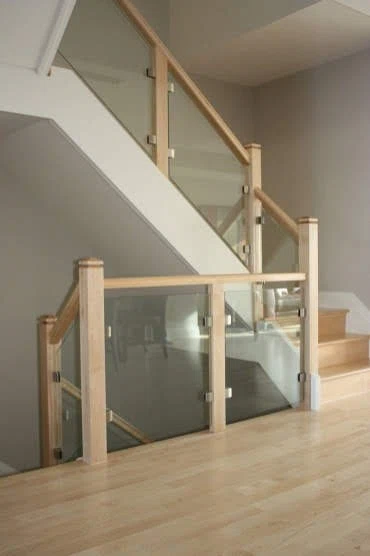 Escalier tournant en érable clair avec garde-corps de verre