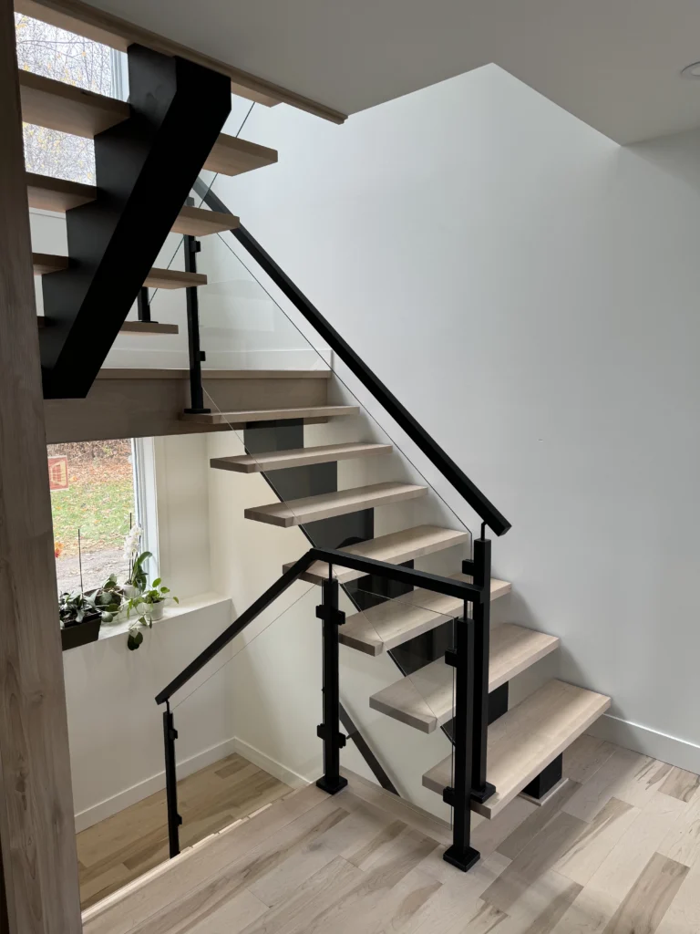 Escalier suspendu en érable clair sur limon d&rsquo;acier noir