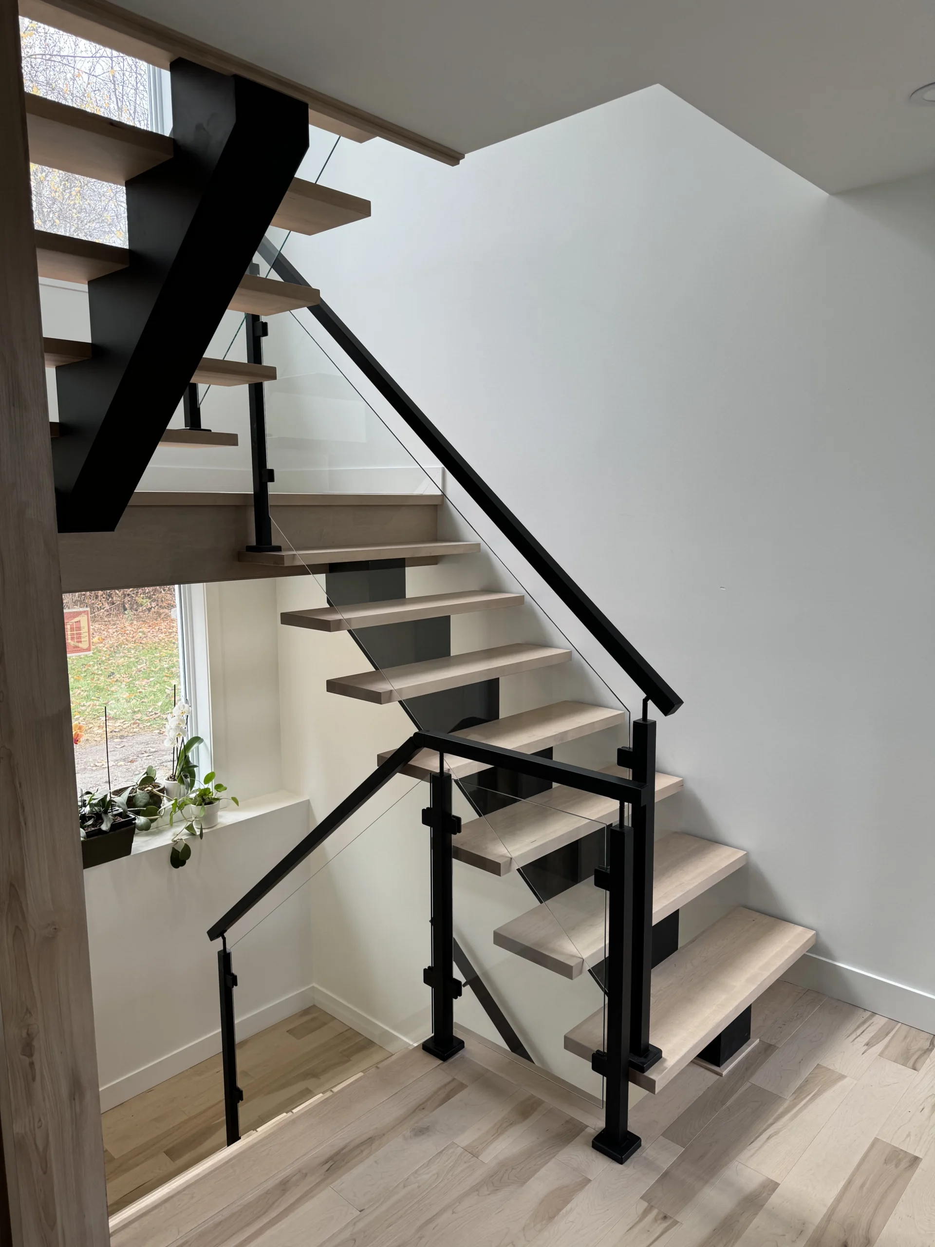 Escalier suspendu en érable clair sur limon d&rsquo;acier noir — vue principale