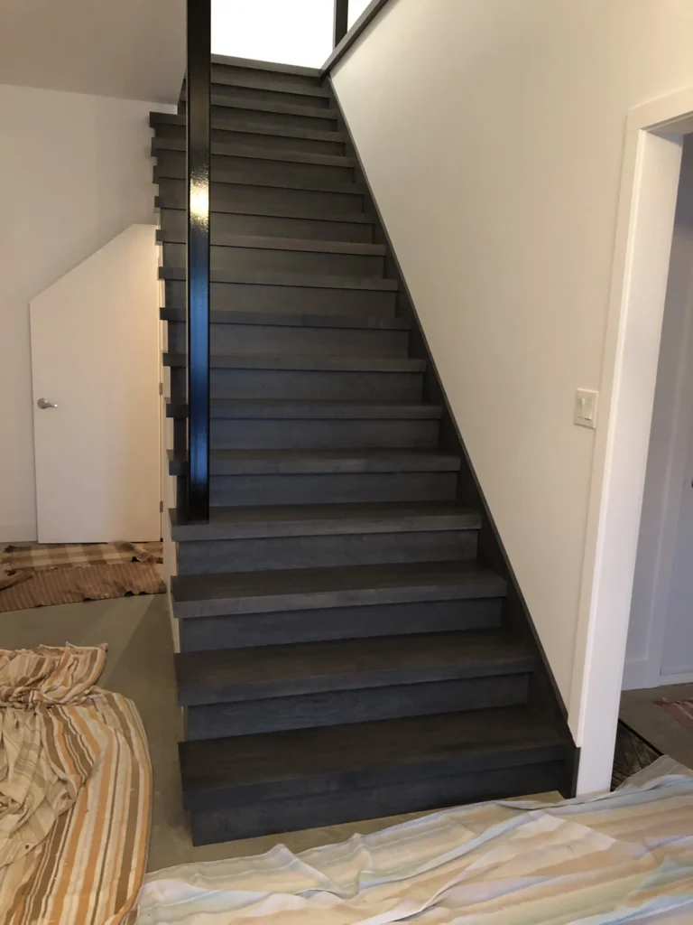 Escalier droit en bois teinté gris foncé à main courante d'acier, Beloeil