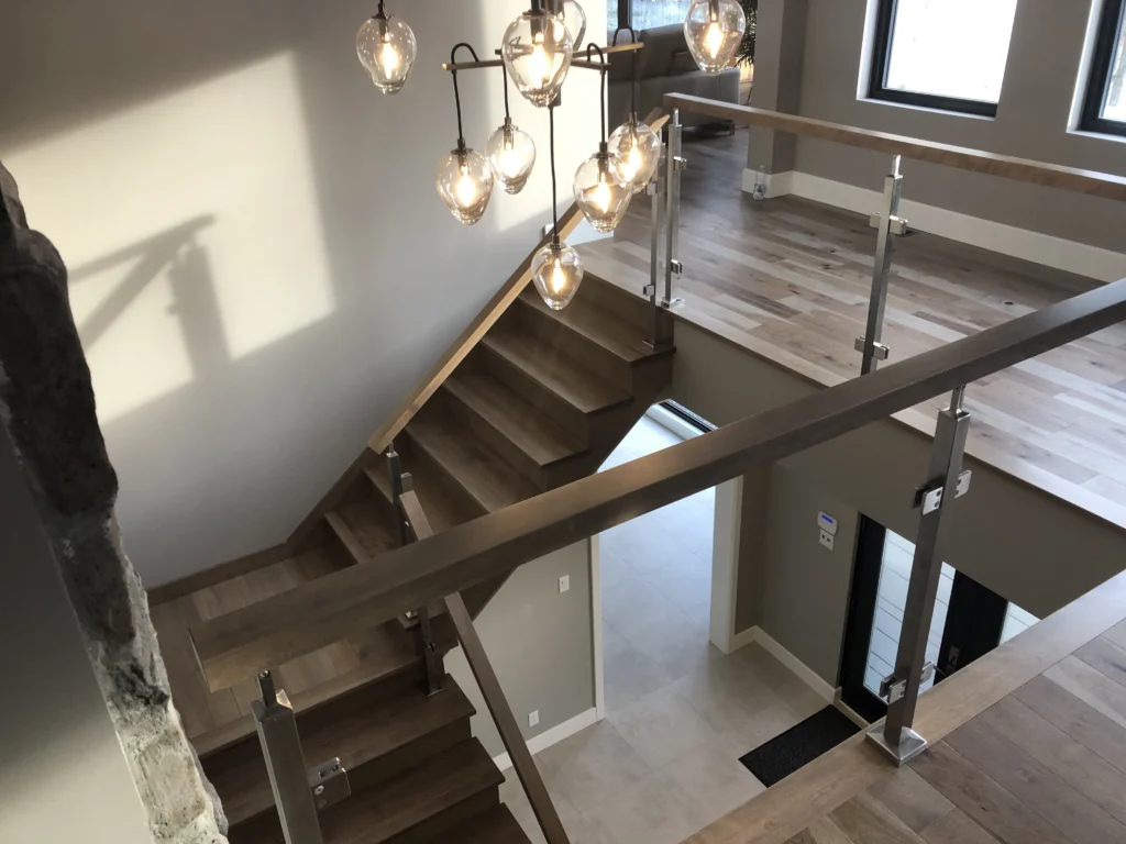 Escalier tournant en chêne avec garde-corps de verre et inox