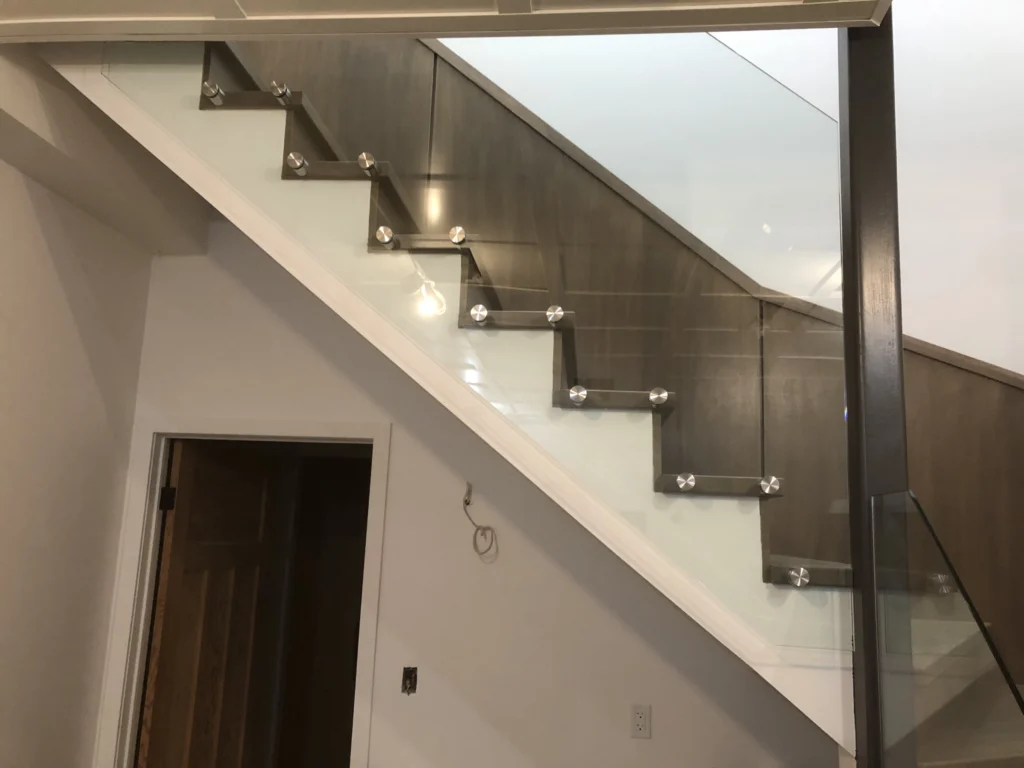 Escalier tournant en bois teinté gris avec panneaux de verre