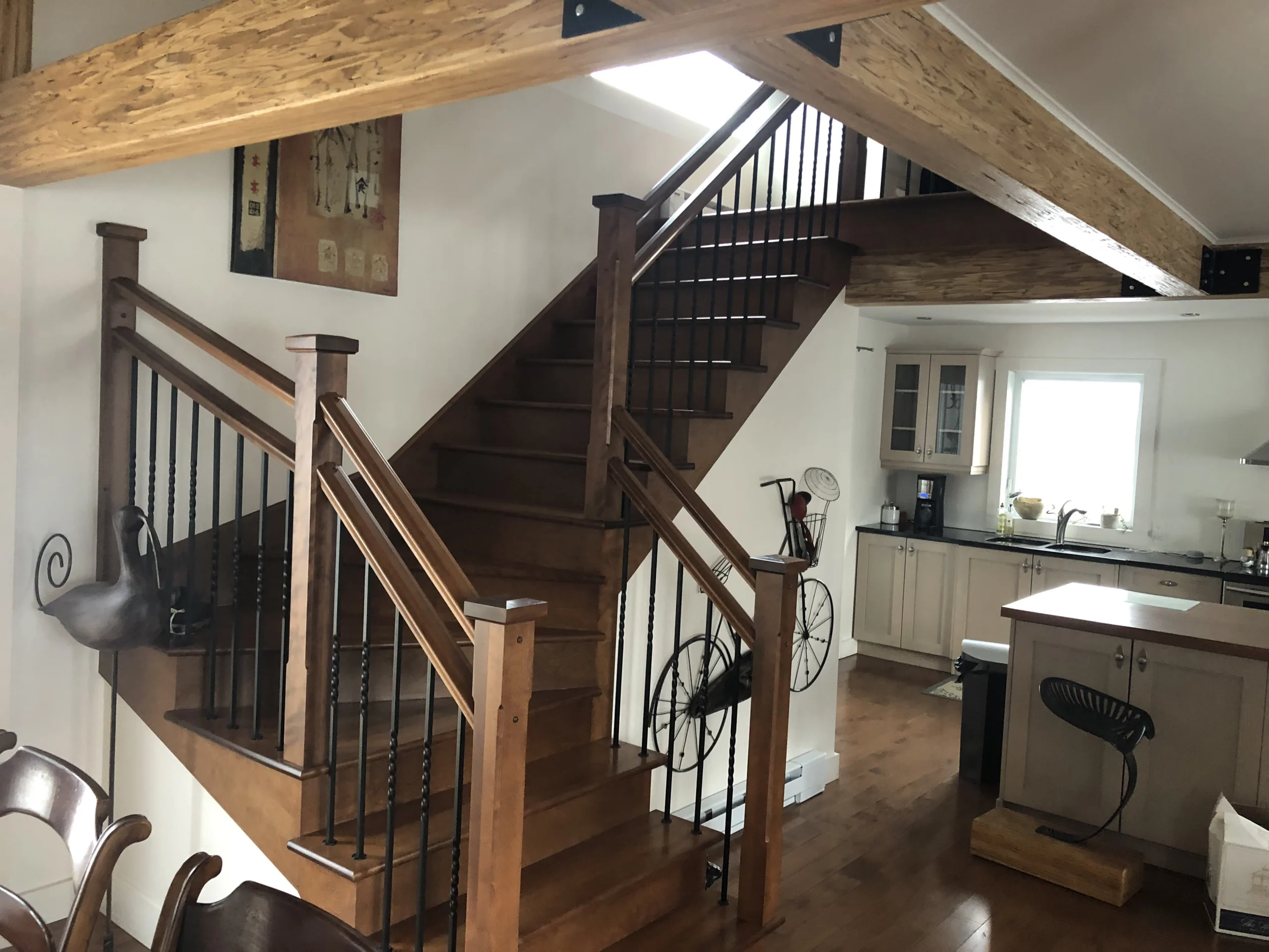 Escalier tournant en bois teinté miel à barreaux de fer forgé — vue principale