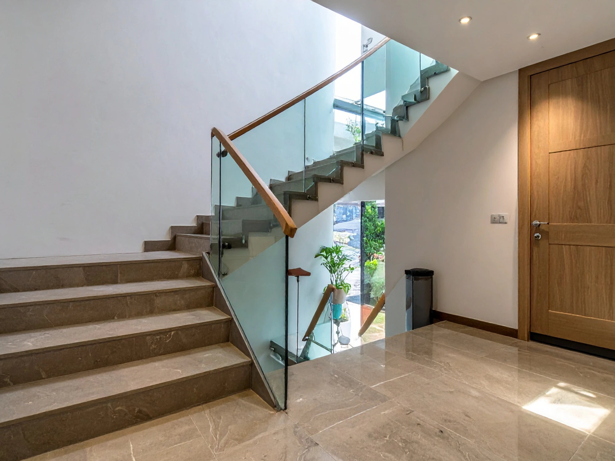 Garde-corps de verre avec poteaux d'acier noir et main courante de bois foncé sur un escalier droit à Sainte-Julie
