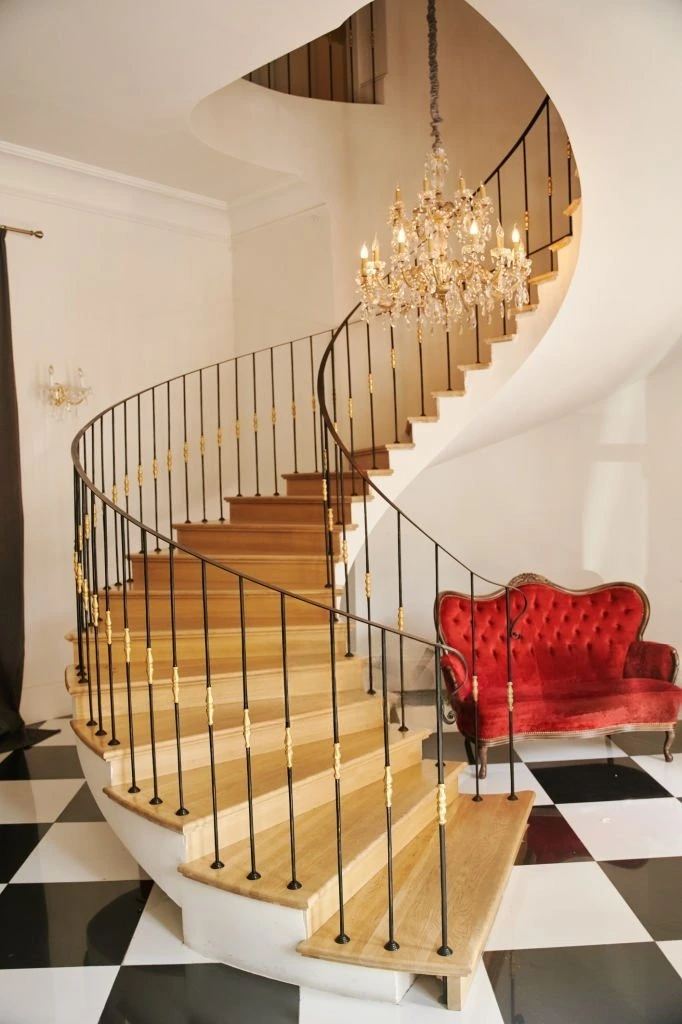 Escalier hélicoïdal à main courante et barreaux de fer forgé