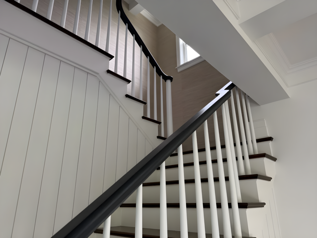 Escalier tournant classique à barreaux blancs et main courante foncée