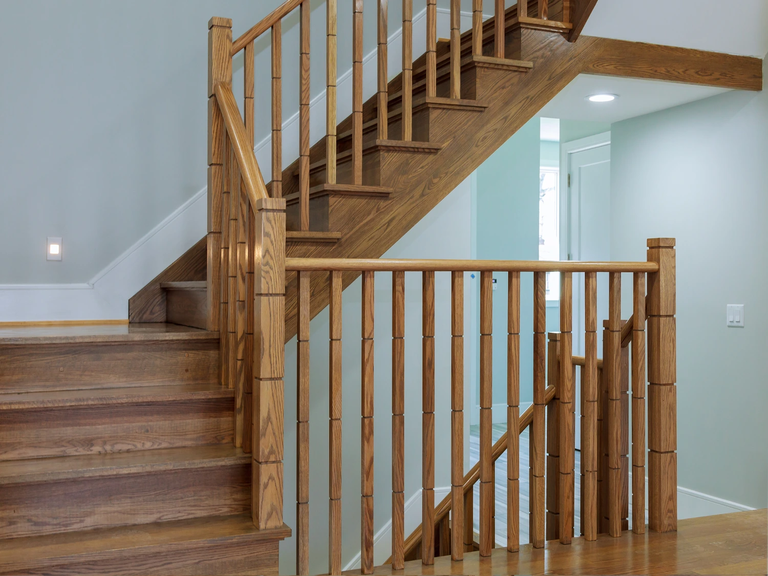 Escalier droit en érable clair à marches ouvertes bordé d'un claustra à lattes de bois, résidence à Longueuil