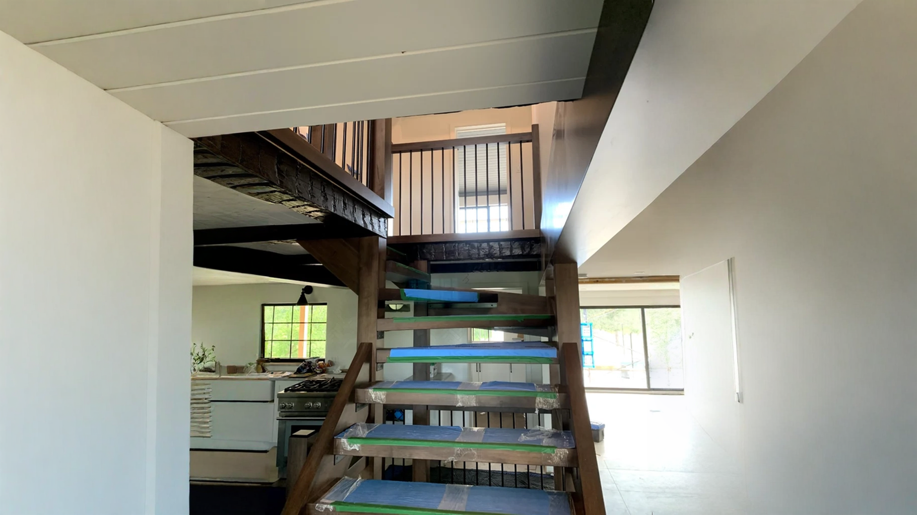 Escalier tournant de bois foncé à contremarches ouvertes et barreaux de métal noir — vue principale