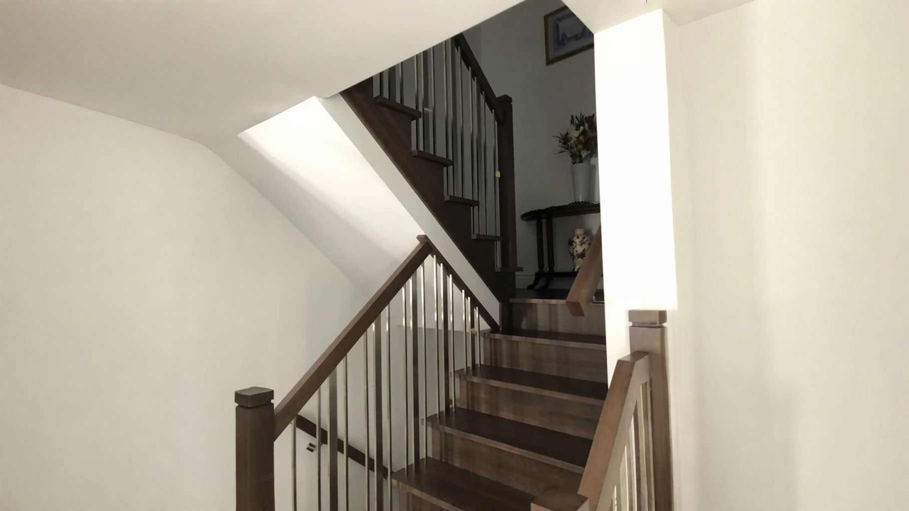 Escalier tournant en bois teinté brun foncé avec barreaux nickelés brossés — vue principale