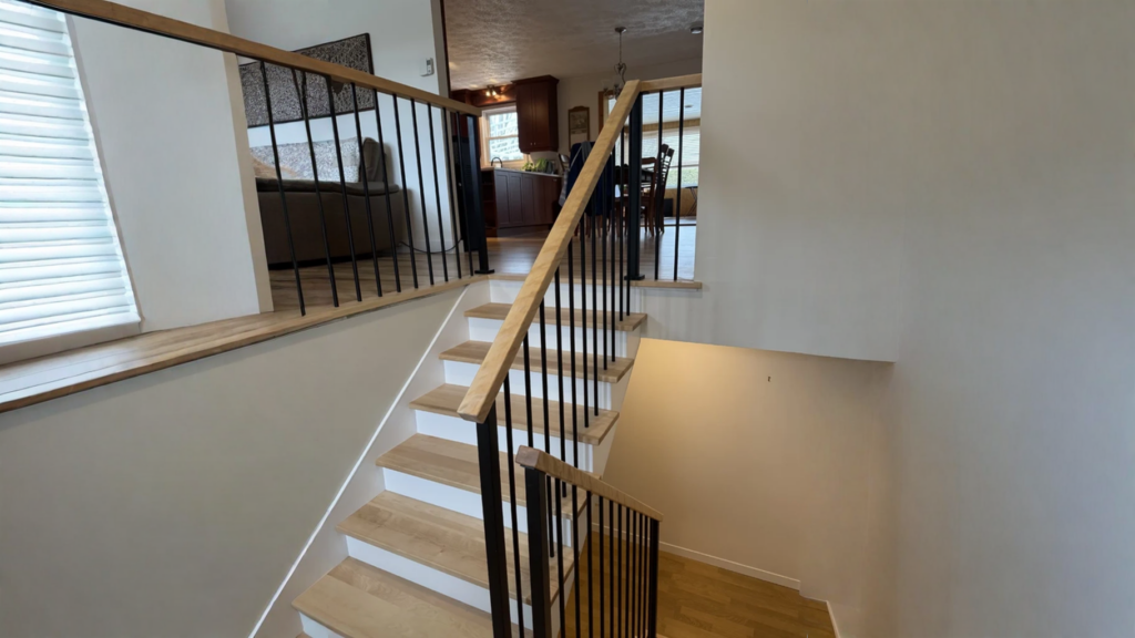 Rénovation d’escalier à paliers, barreaux métalliques noirs et marches de bois blond