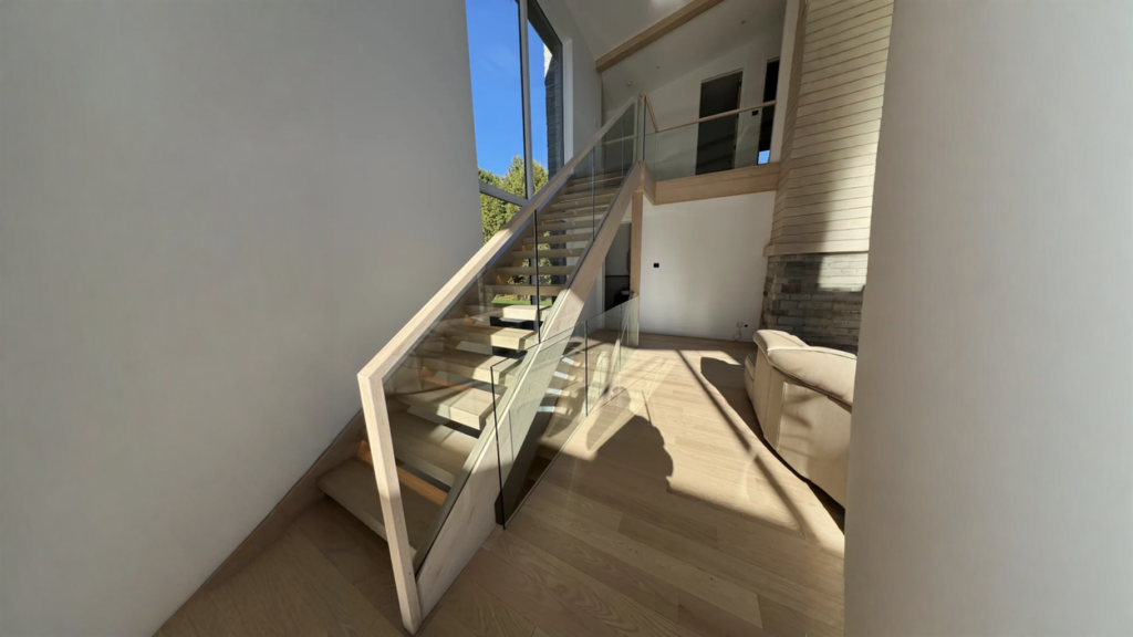 Escalier suspendu en chêne blanchi à garde-corps de verre