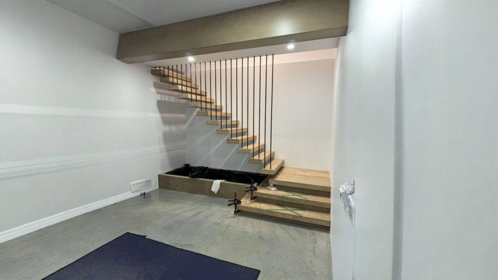 Escalier suspendu en chêne à marches flottantes et garde-corps de tiges noires