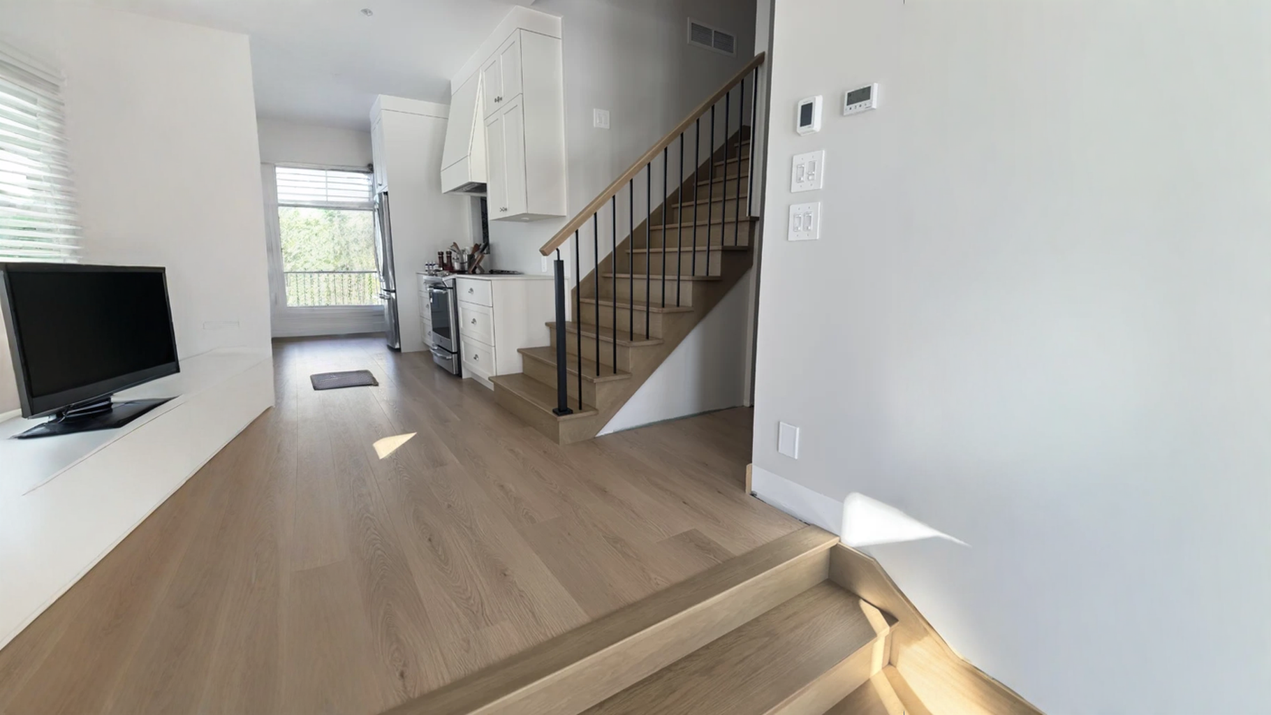 Straight staircase in white oak to balusters black steel on open kitchen — vue principale