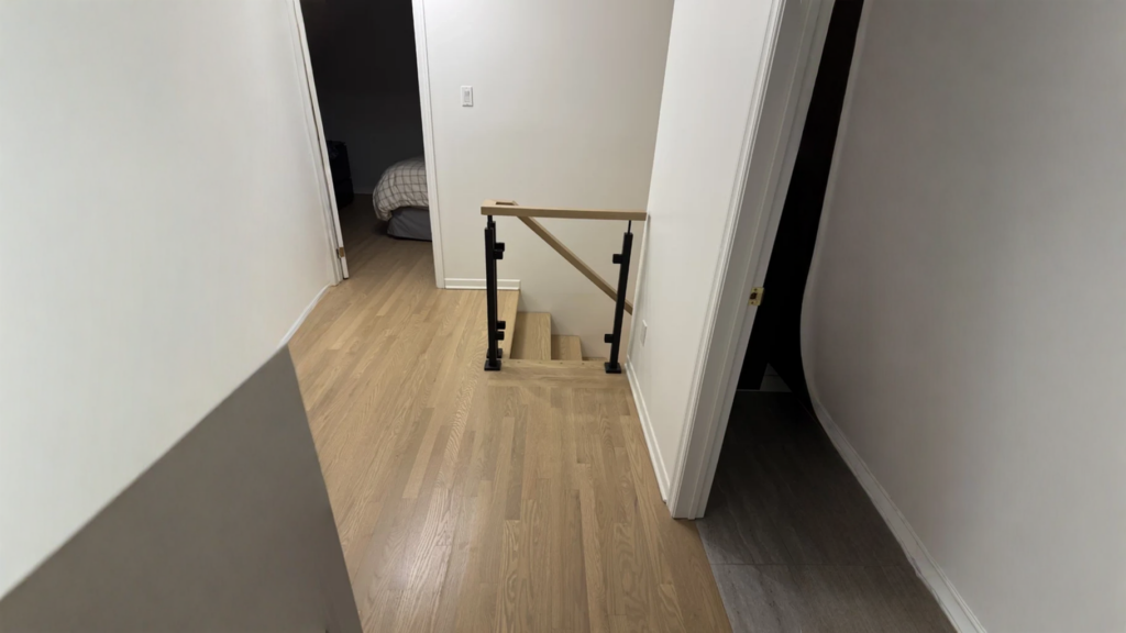 Garde-corps de palier en bois pâle et poteaux métalliques noirs