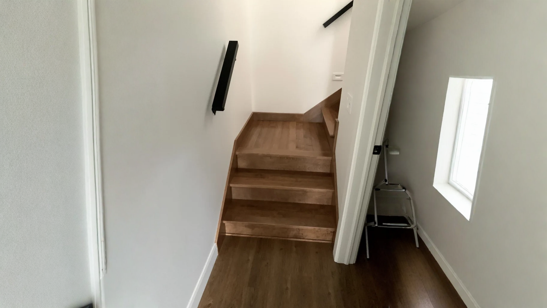 Winder staircase compact hardwood with black metal wall hands — vue principale