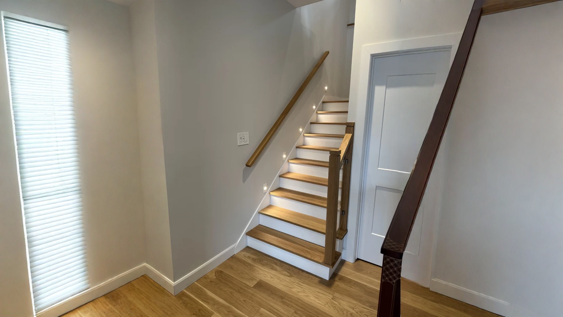 Escalier tournant en chêne blanc à contremarches blanches et garde-corps de verre — vue principale
