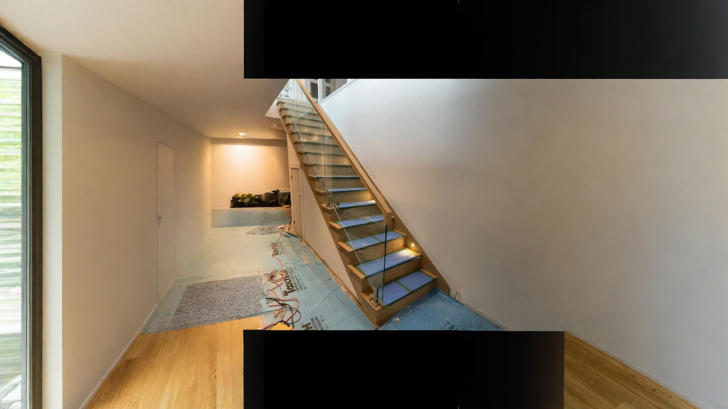 Escalier tournant à barreaux d’acier noir et bois teinté gris