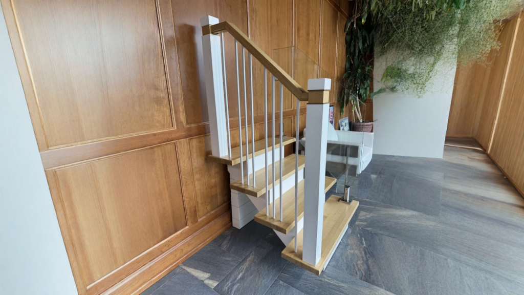 Escalier tournant à barreaux métalliques et verre sur boiserie de bois