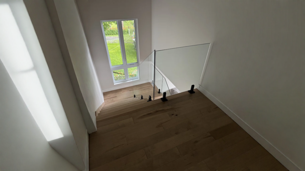 Escalier droit en érable brun chaud à garde-corps de verre sans cadre