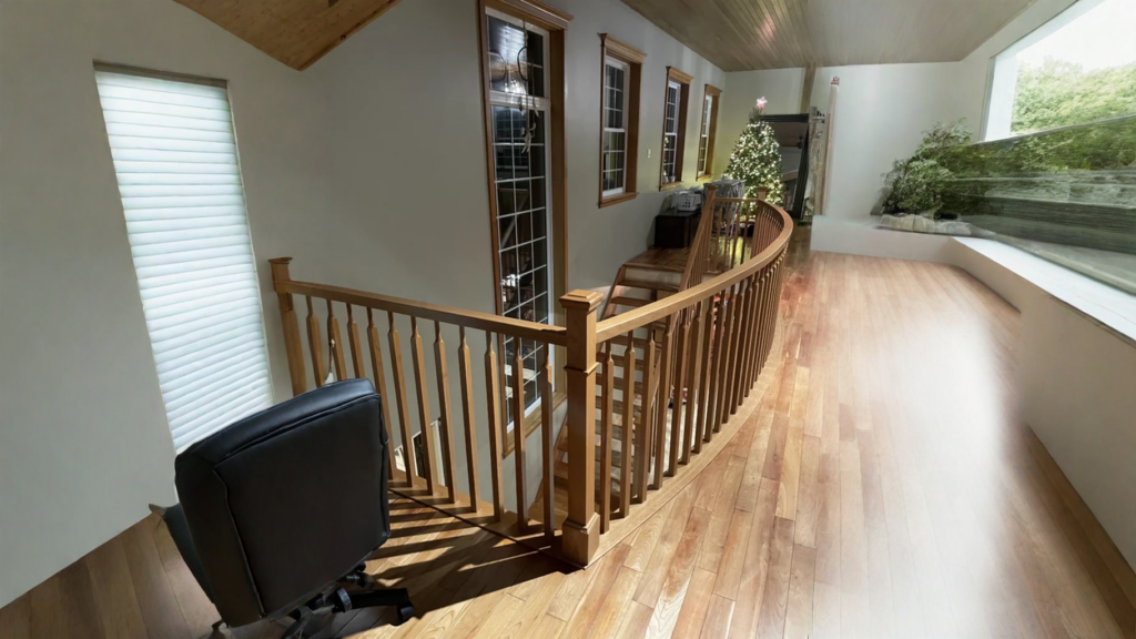 Galerie de mezzanine courbe à barreaux de bois au-dessus d’un escalier