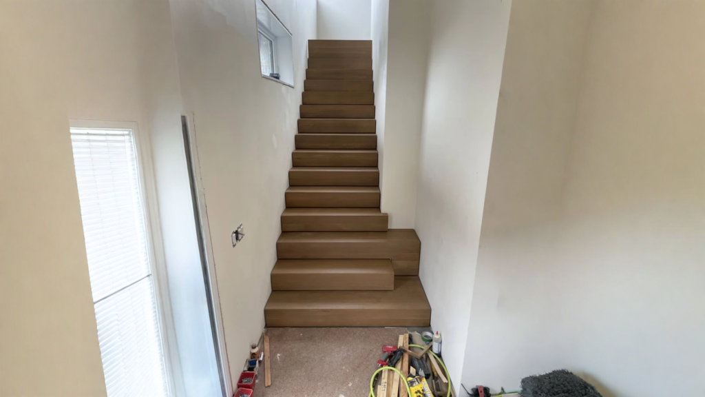 Escalier droit encloisonné en bois franc teinté brun