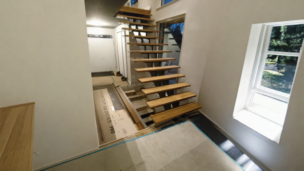 Escalier suspendu à limon central d’acier et marches de bois blond