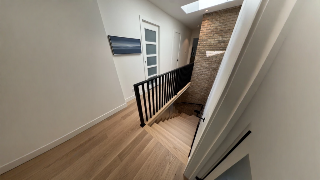 Escalier tournant en chêne blanc à garde-corps de métal noir