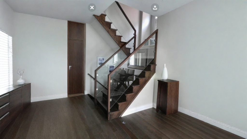 Escalier tournant en bois foncé avec garde-corps de verre