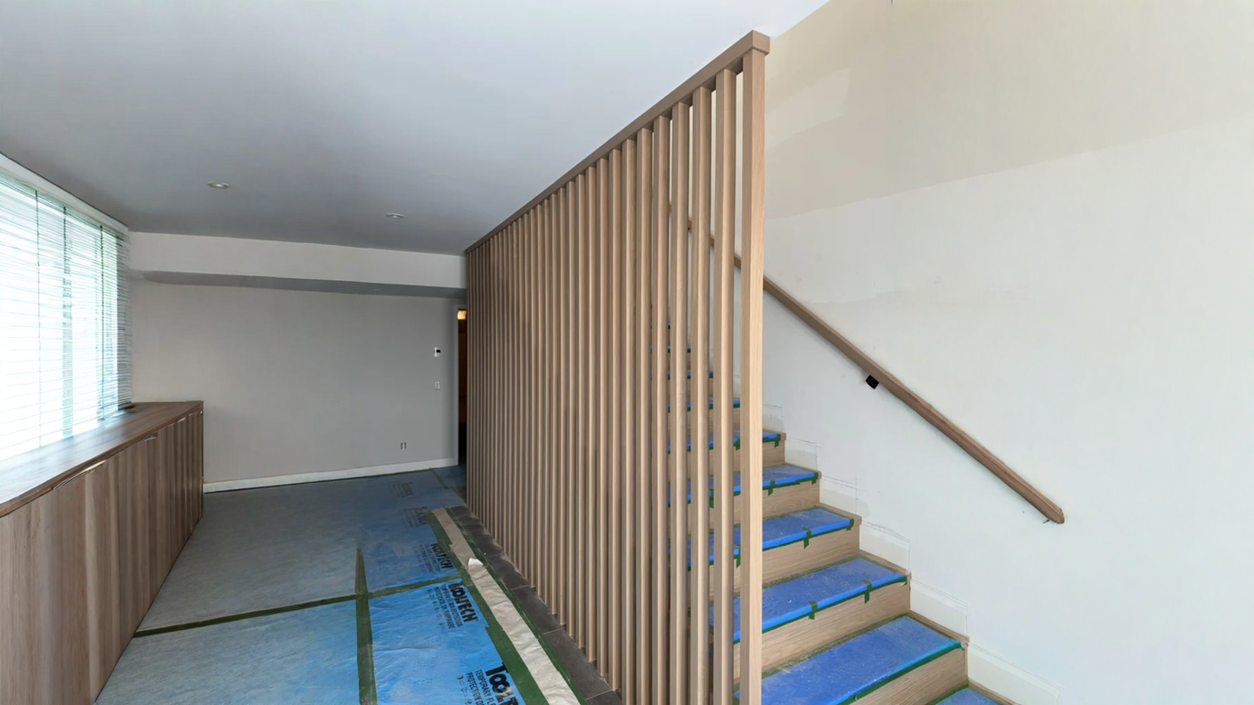 Escalier droit habillé d’un claustra de tasseaux verticaux en chêne blanc — vue principale
