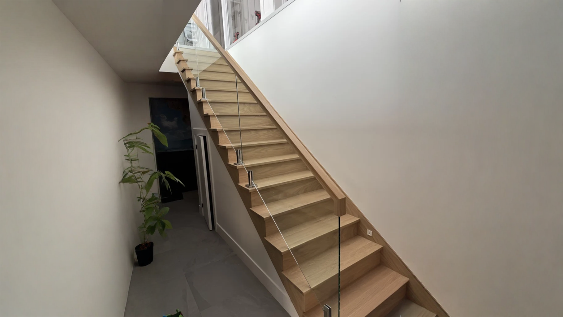 Escalier droit en chêne blond à garde-corps de verre et main courante de bois — vue principale