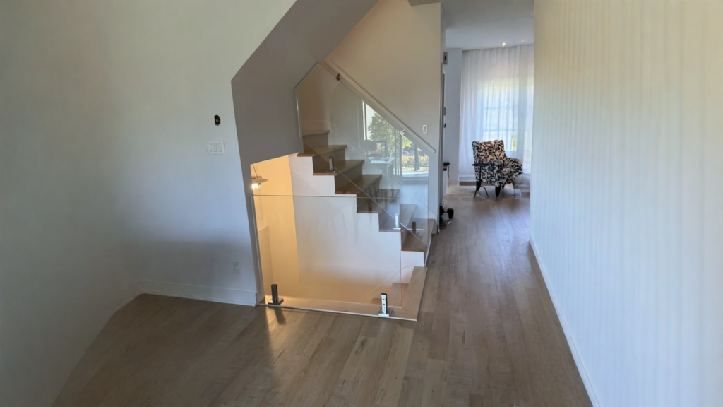 Escalier suspendu à marches de bois clair et garde-corps de verre