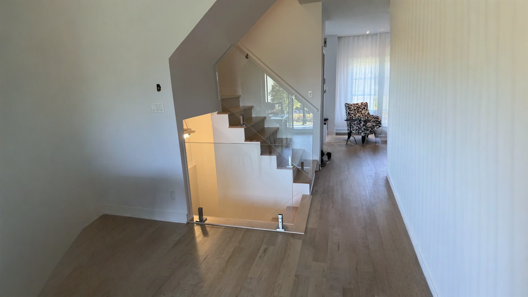 Escalier suspendu à marches de bois clair et garde-corps de verre — vue principale