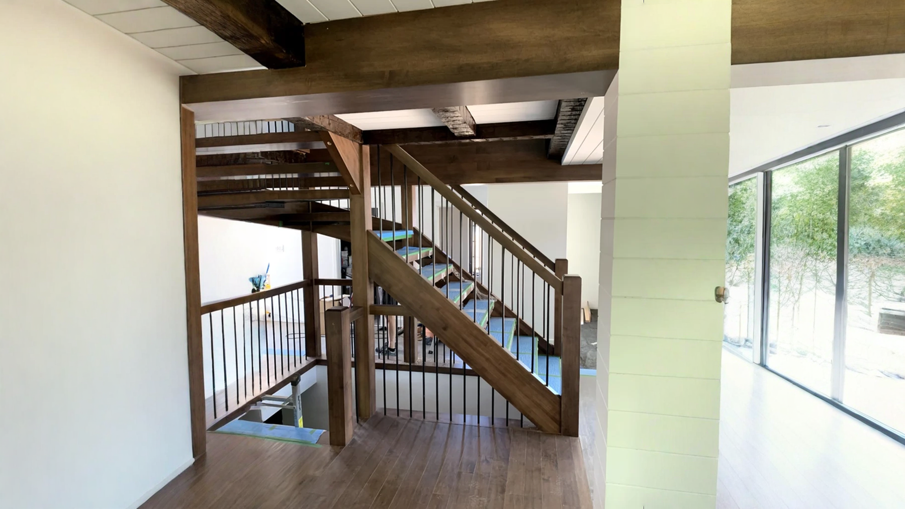 Winder staircase of dark wood to balusters of black metal and visible posts — vue principale