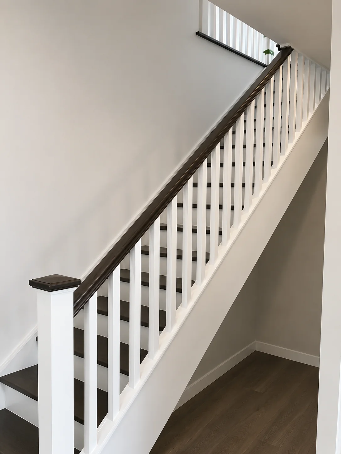 Escalier droit à barreaux blancs et main courante en bois teinté — vue principale