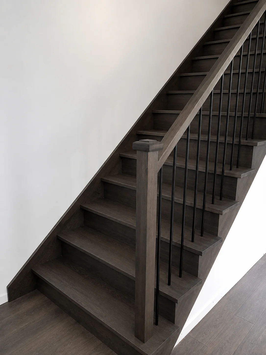 Escalier tournant en chêne teinté gris fumé avec barreaux métalliques noirs — vue principale